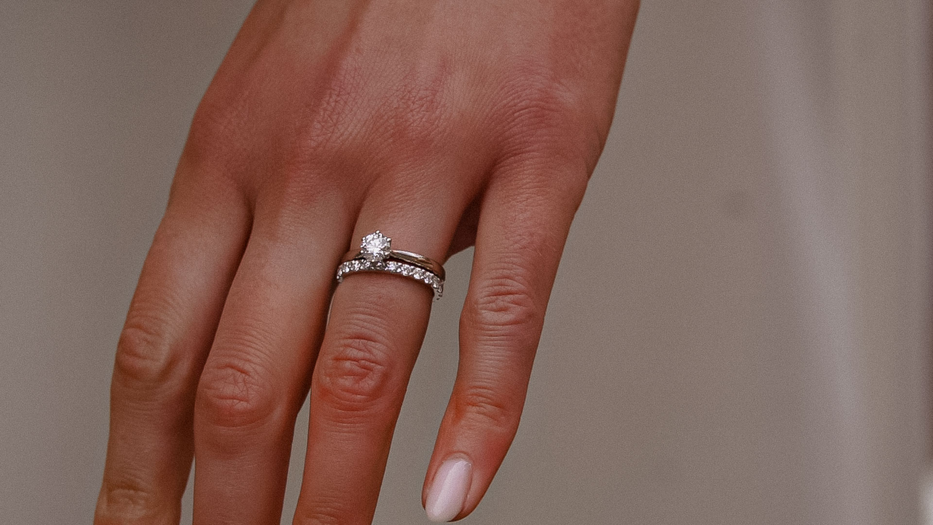 Detaljbild av hand med vigsel- och förlovningsring